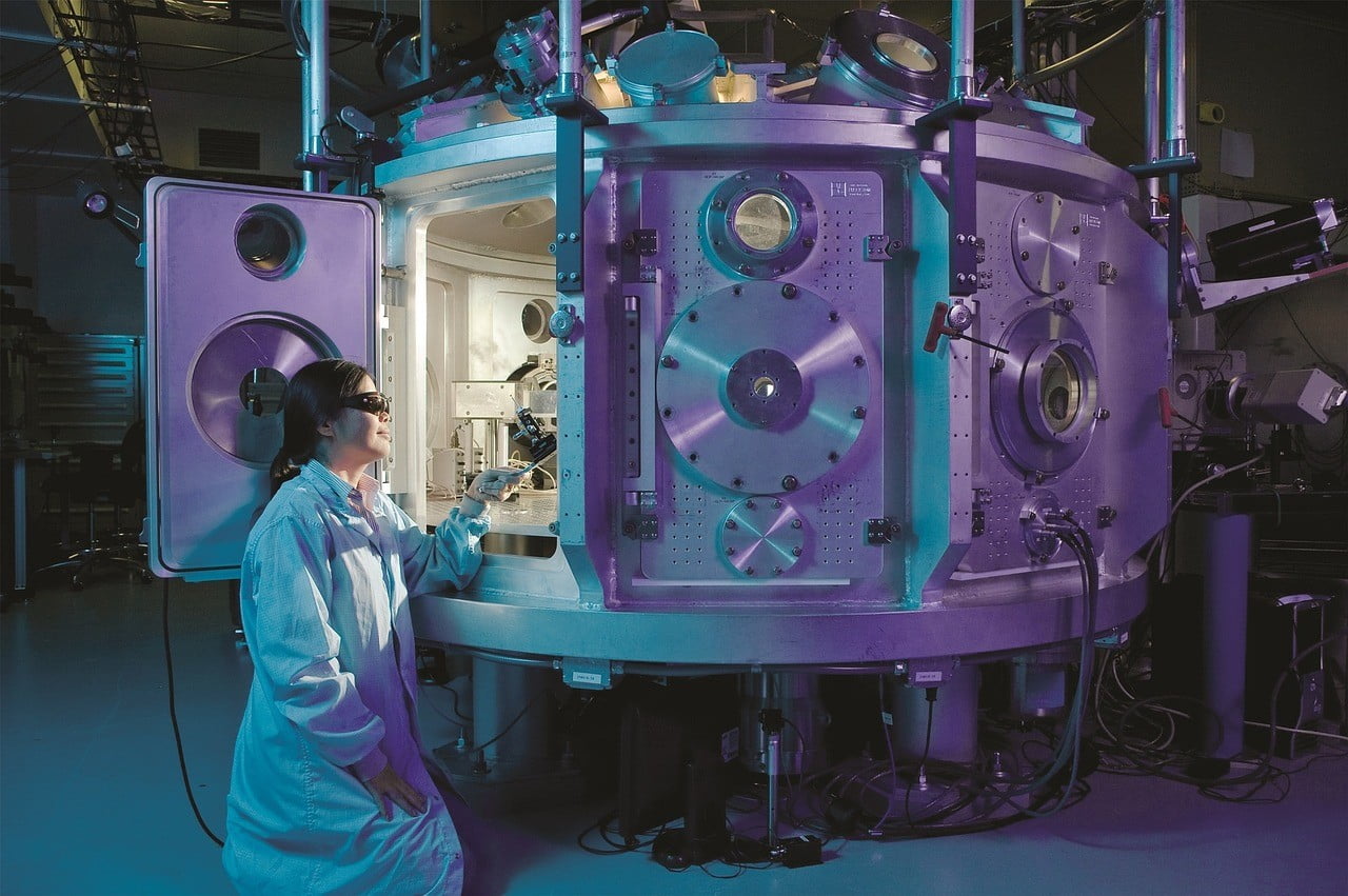 Woman in white coat and uv-glasses working with science