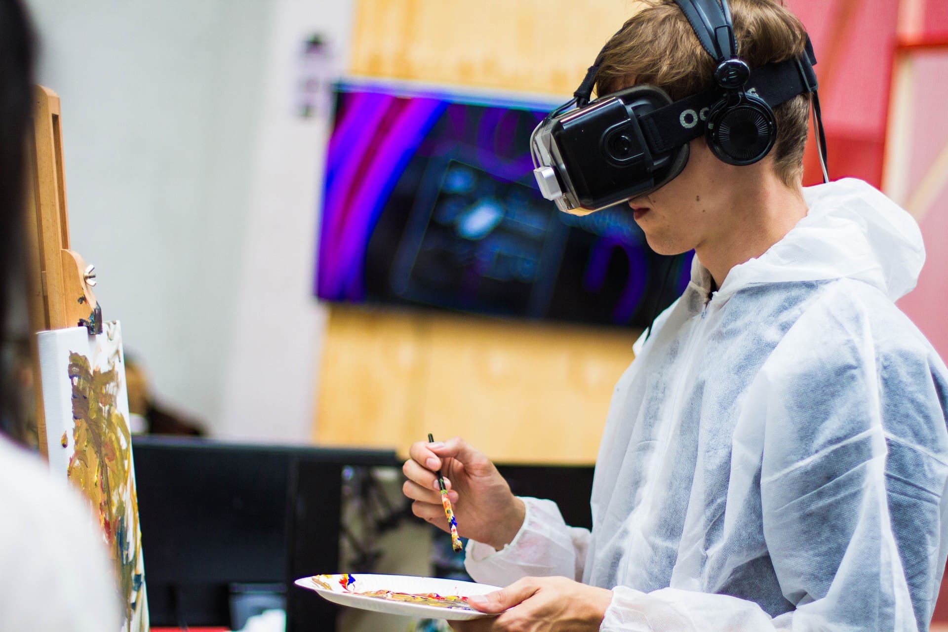 boy wearing VR glasses while painting.