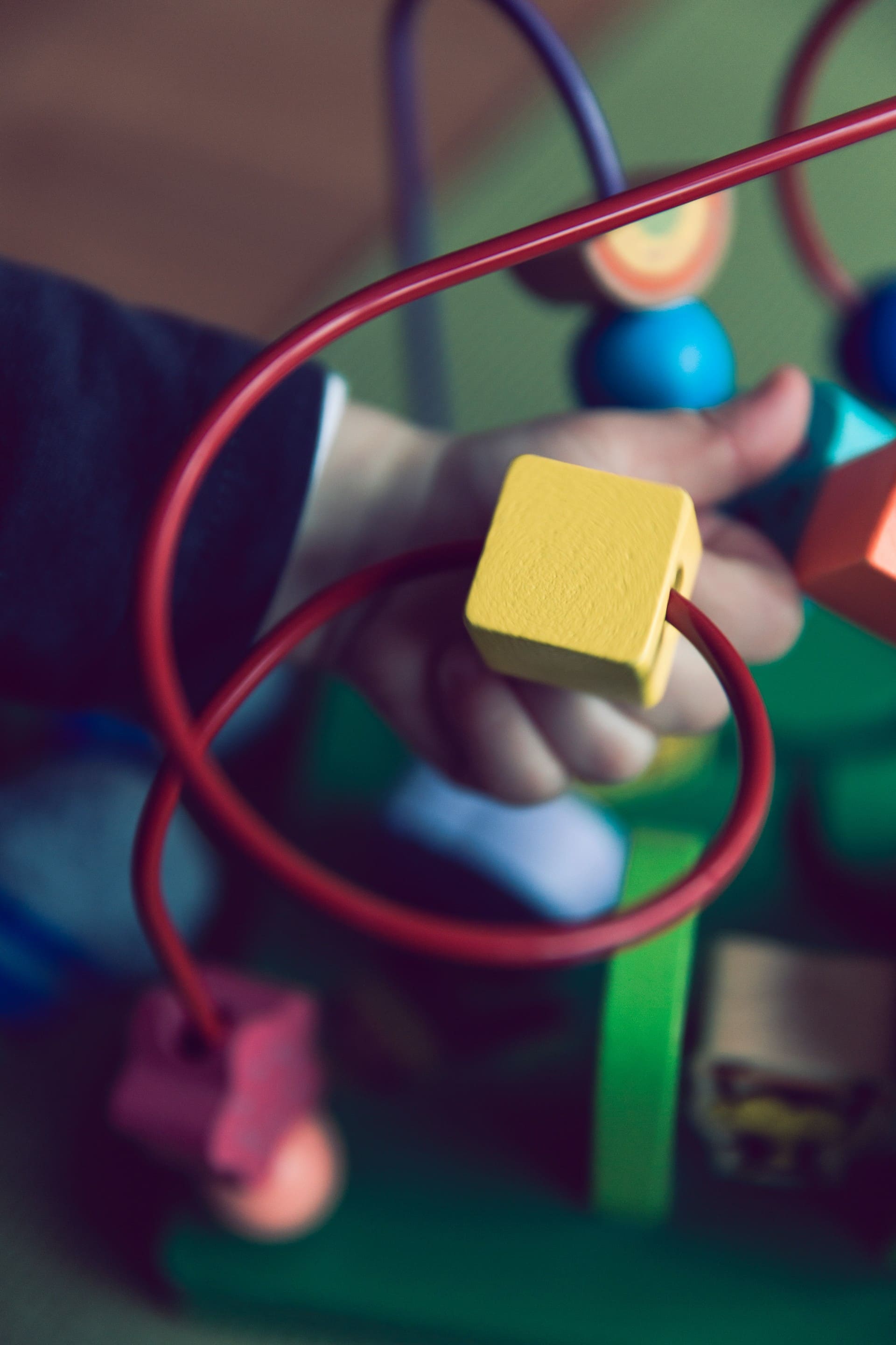 yellow brick in a toddlers hand moving through a wire
