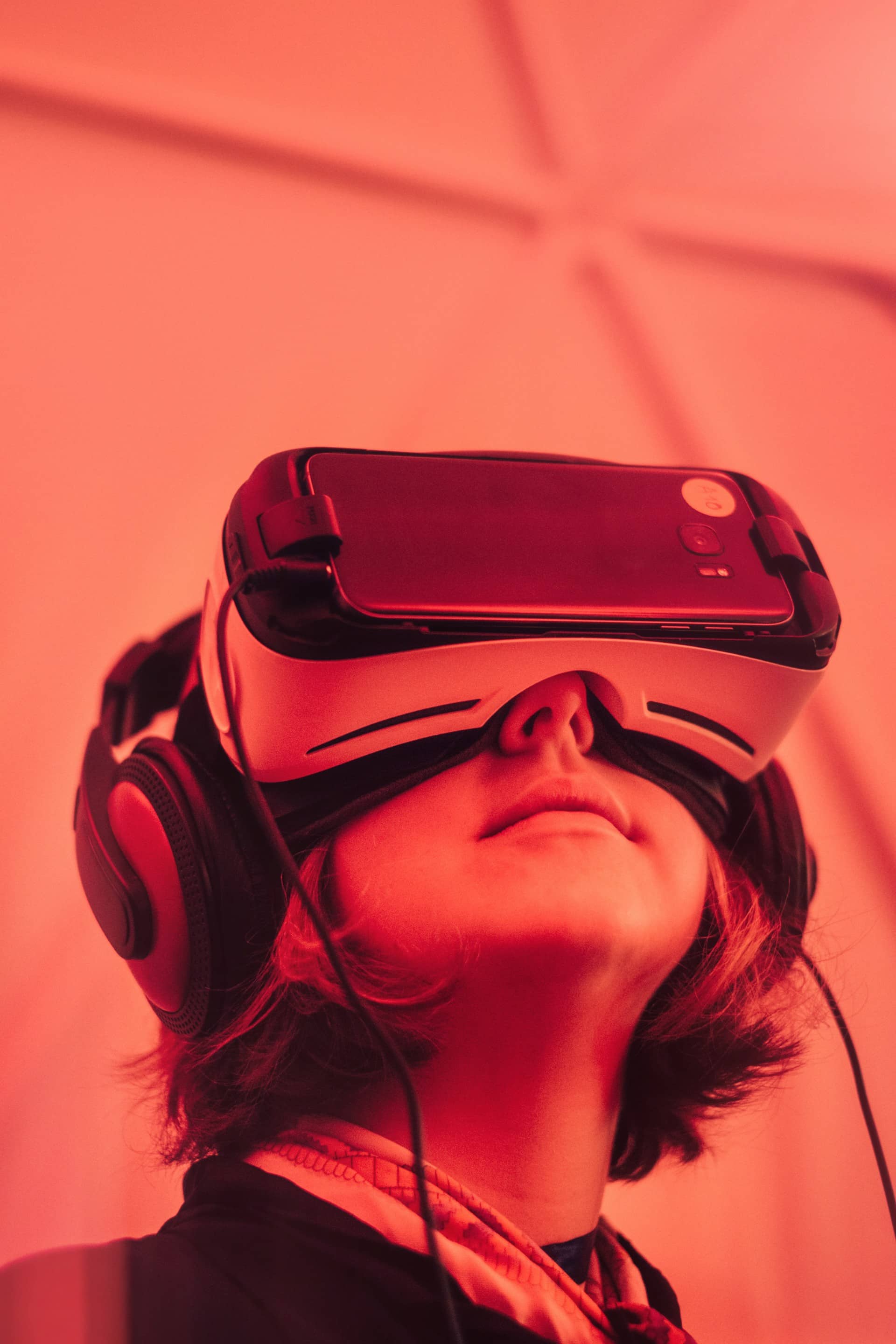 Girl in a red lighting room wearing virtual reality glasses 